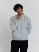 A male model wears One Dna brand heather gray mock neck sweatshirt