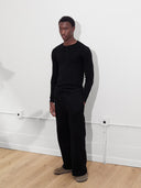 male model wears black rib knit henley one dna clothing