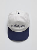 one dna white and navy hat with michigan in script font gray background